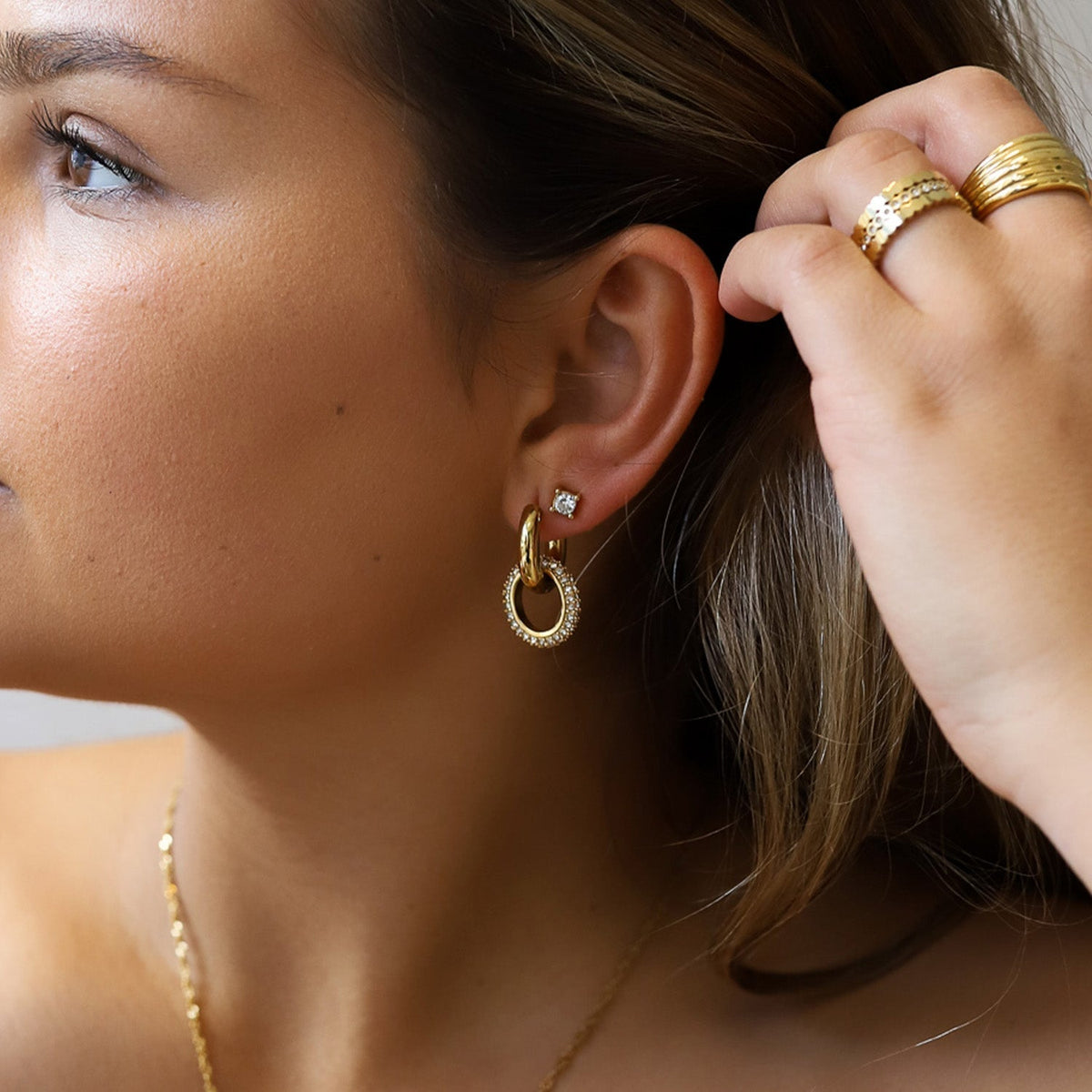 Double hoop earrings in gold-toned metal alloy showing hinge clasp detail