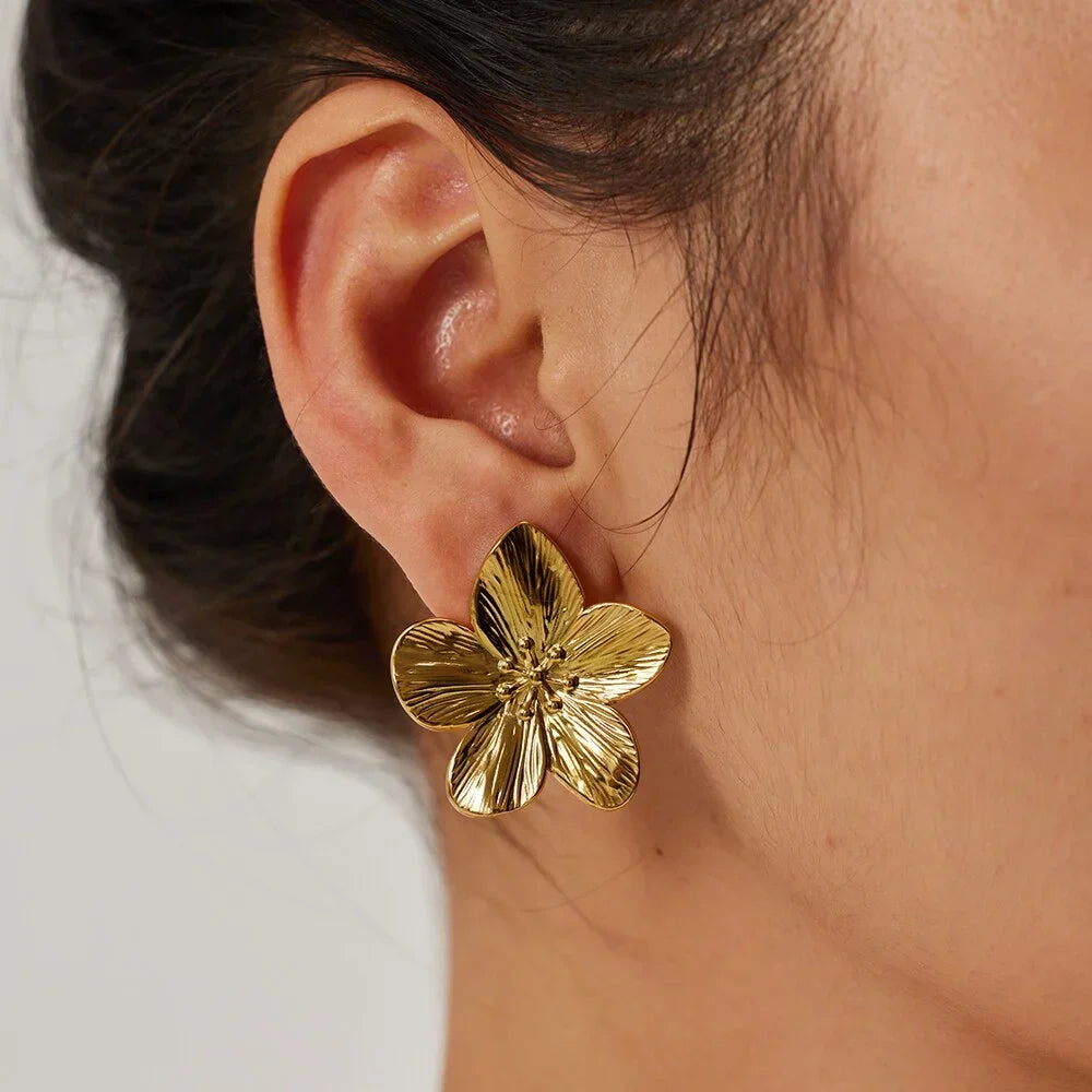 Gold-colored metal flower earrings with smooth petal surface and stud backing