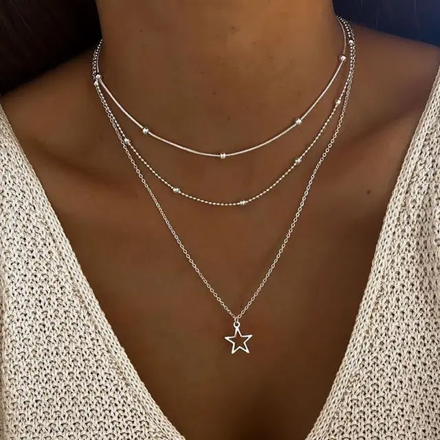 Layered star pendant necklace with multiple thin chains in varying lengths