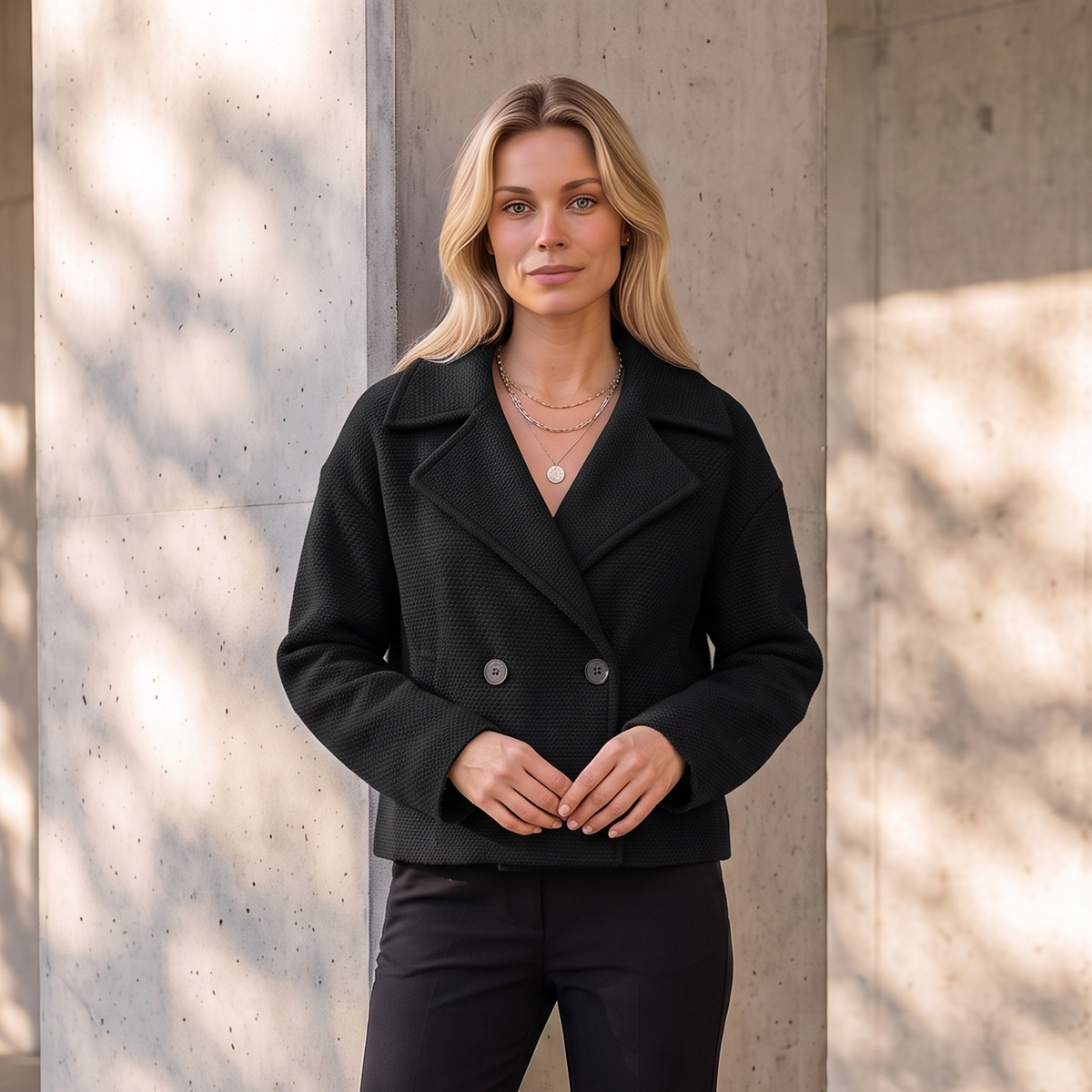 Short double-breasted women's coat with long sleeves and smooth panel construction