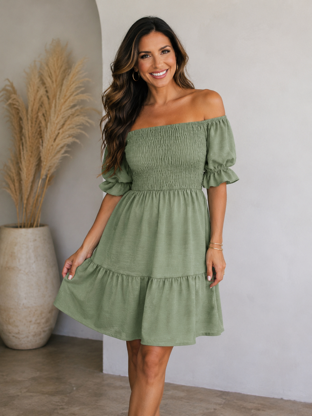 Off-shoulder smocked women's dress featuring a tiered flared skirt and short puff sleeves