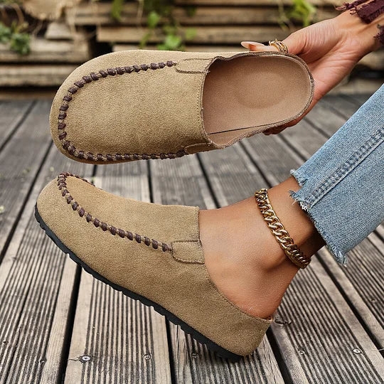 Women's suede slip-on clogs displayed to show upper stitching and closed round toe