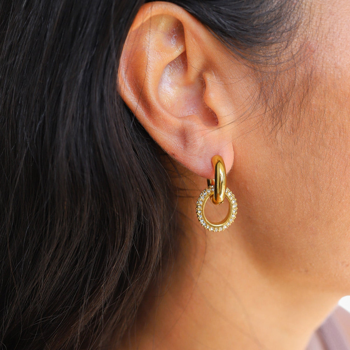 Interlocking double ring earrings in gold-toned finish displayed close up to show texture contrast