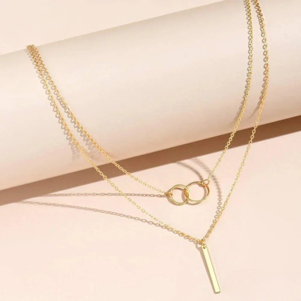 Women's minimalist layered necklace with stacked chain design, close-up