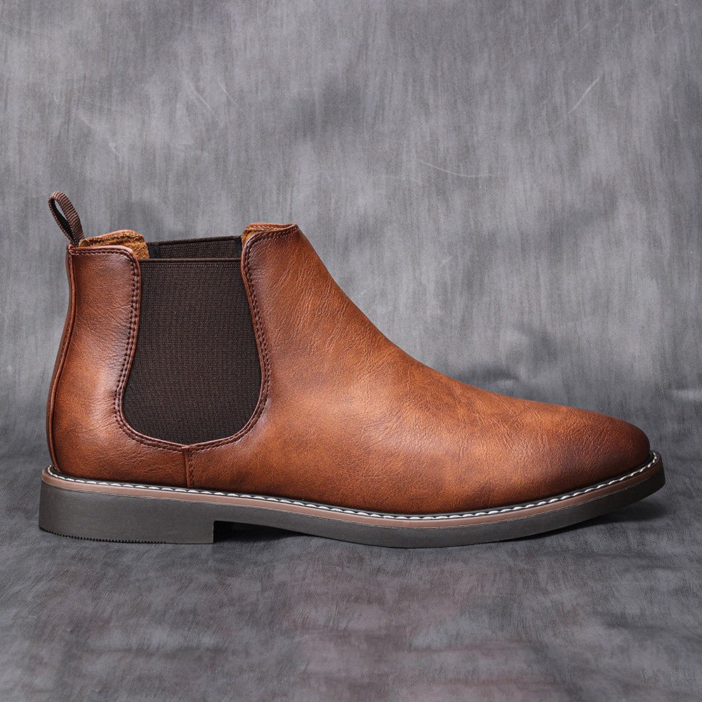 Men's slip-on Chelsea boots showing elastic side panel detail and rubber sole, side view