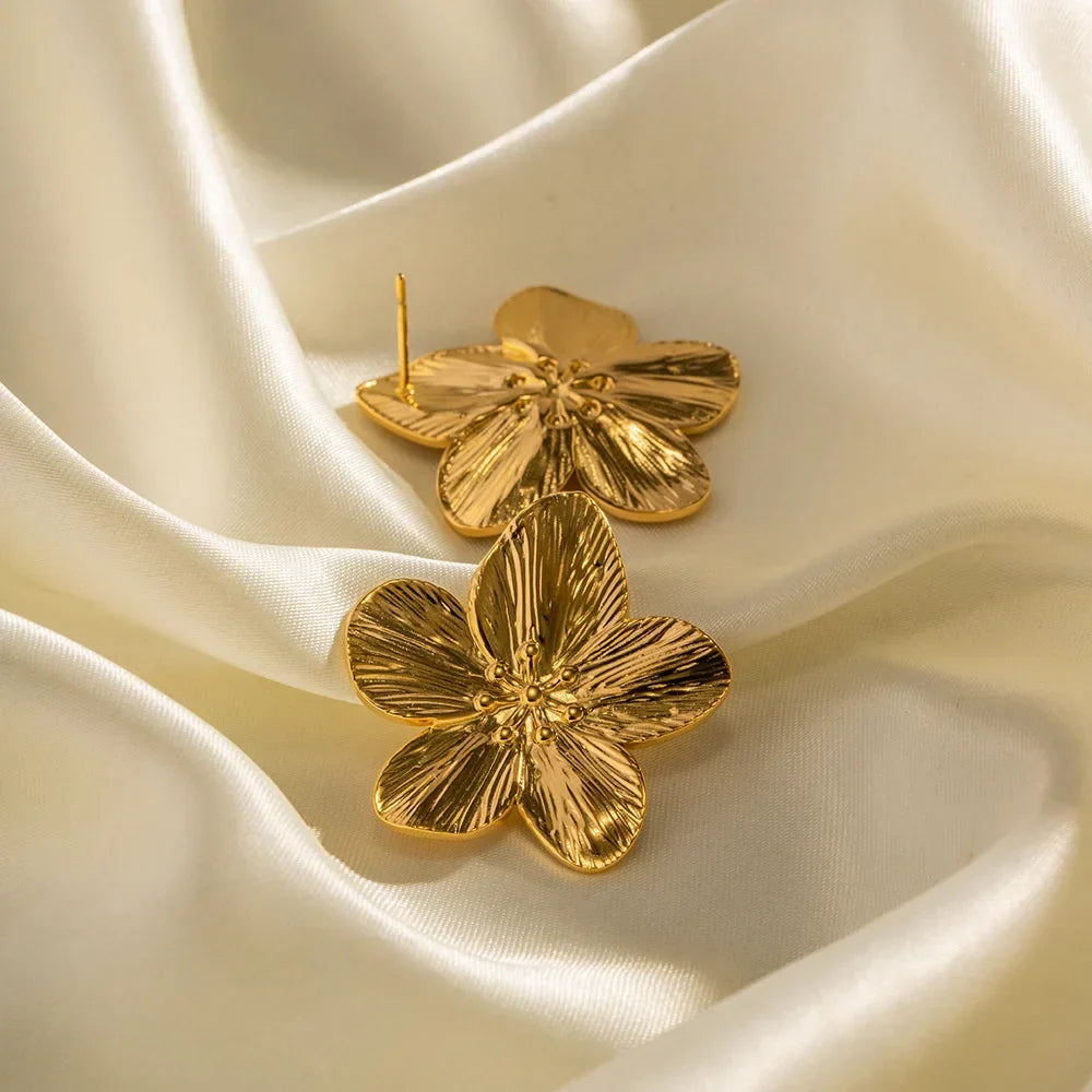 Women's gold-colored flower stud earrings with sculpted bloom detail