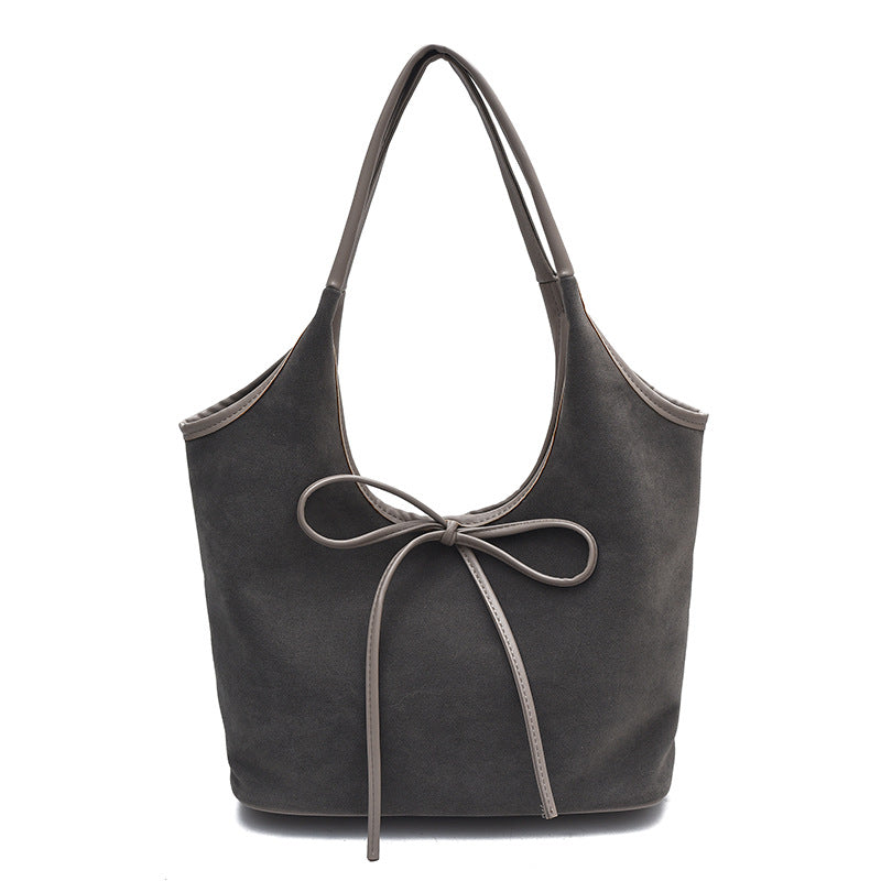 Women's faux suede tote bag with decorative front bow and shoulder straps