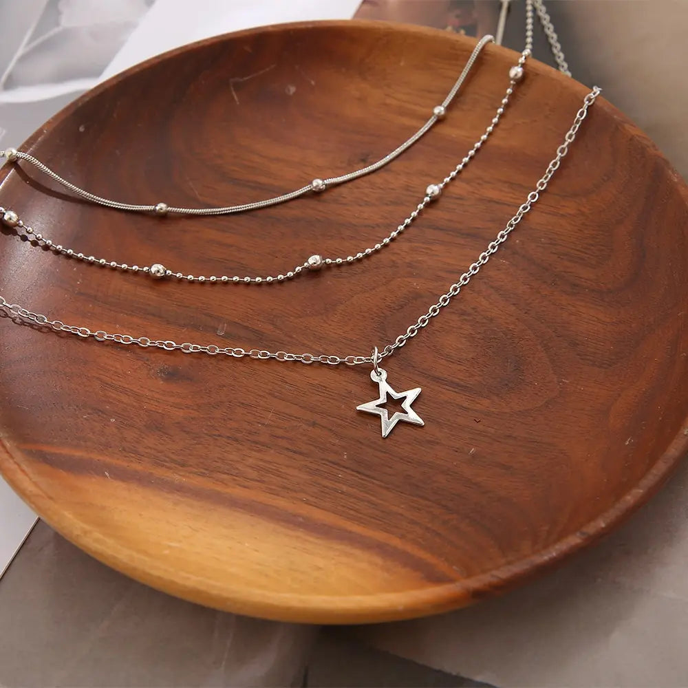 Minimalist layered necklace with star pendant worn as a delicate everyday jewelry piece
